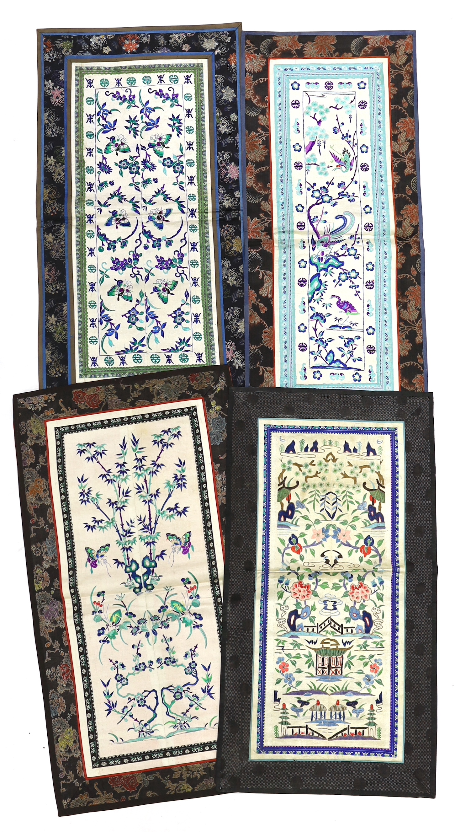 Three pairs of Chinese embroidered sleeve bands, polychrome silk designs on cream silk background, together with a single sleeve band, all bordered with damask silk, longest panel including border 66cm x 35cm wide